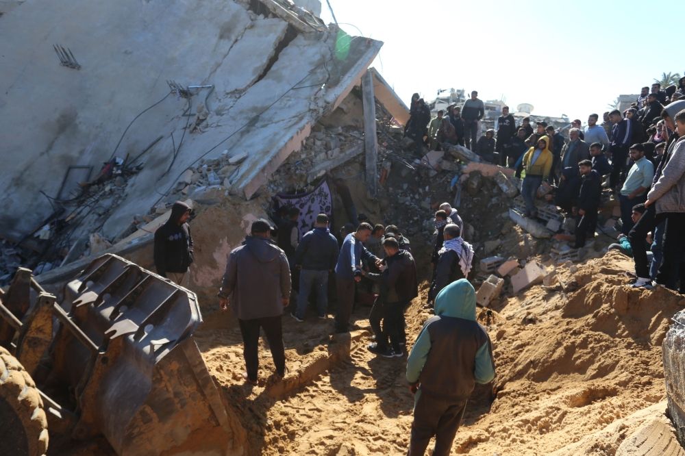 فلسطينيون يبحثون بين أنقاض مبنى في موقع غارة إسرائيلية جنوب قطاع غزة- أ ف ب